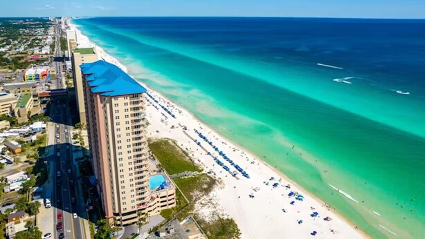 A high-rise hotel with a beach view, multiple balconies, and a pool area. - Sunrise Serenity Resort Condo! (Panama City Beach)