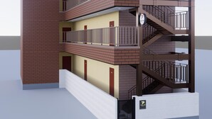 Un edificio de varios pisos con fachada de ladrillo, balcones y una escalera.
