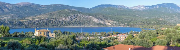 A coastal town with a large lake, surrounded by mountains and greenery.