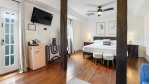 A bedroom with a bed, bedside tables, a TV, and a desk with a computer. - The Shorty Guest House (New Orleans)