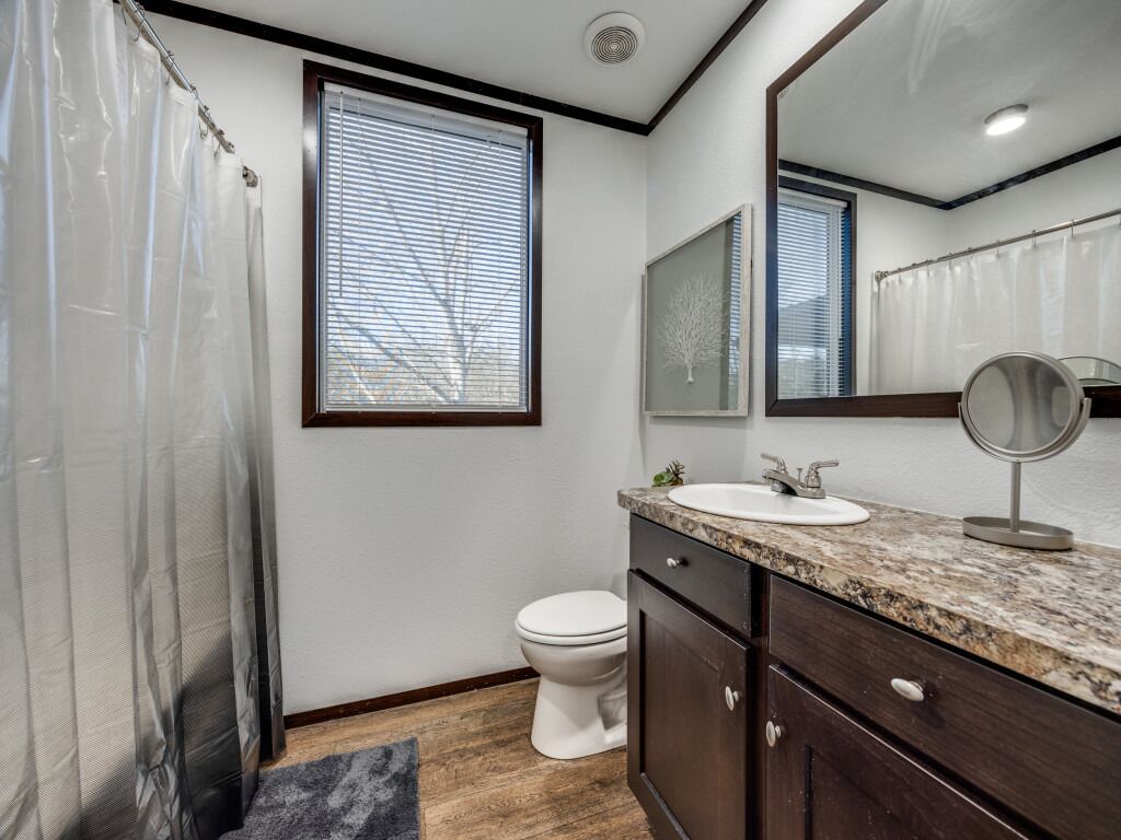 Une salle de bain avec des toilettes, un lavabo et un miroir.
