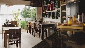 An interior with a bar area, wooden ceiling beams, and a view of the outdoors.