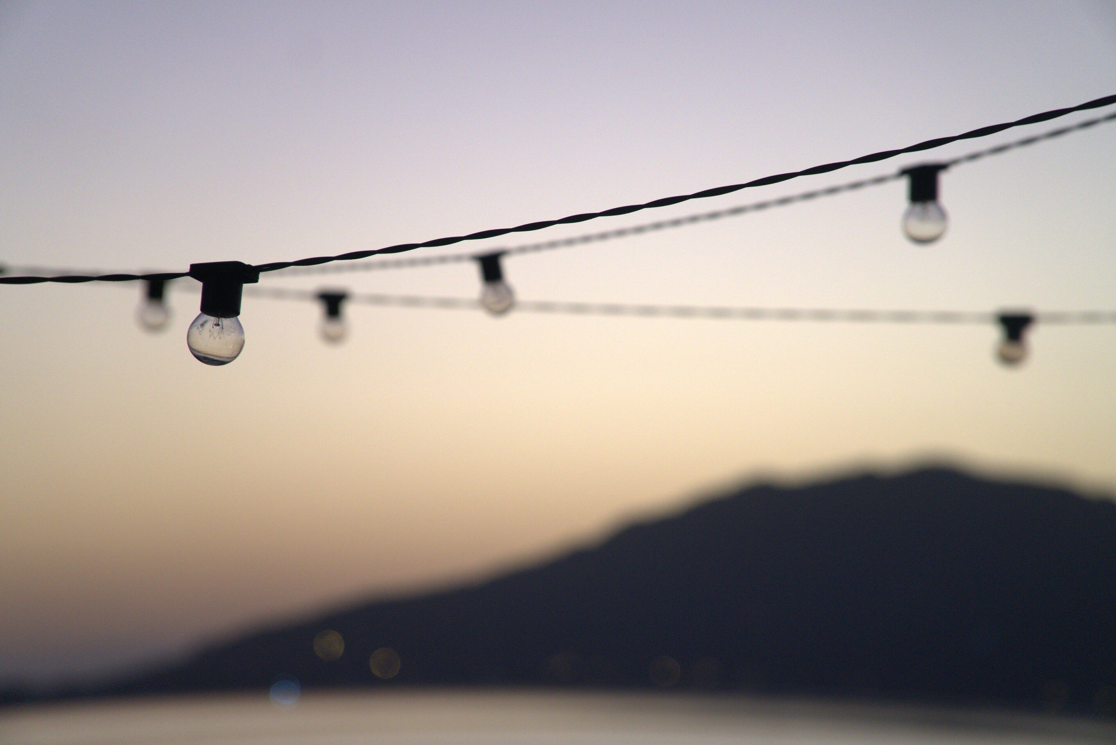 Une guirlande lumineuse se détachant sur un arrière-plan montagneux flou.