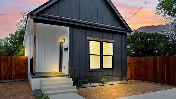 A single-story house with a dark exterior, a front porch, and a visible number '916' on the door. - Tiny Twin Lia, New 2 bedroom Fully Furnished Midterm in beautiful Waco (Waco)