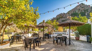 An outdoor patio with tables and chairs, surrounded by trees and a mountainous backdrop. - 3 bedroom lovely home in Montejaque (Montejaque)