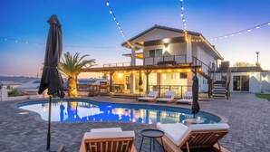 A swimming pool with lounge chairs, a covered seating area, and string lights. - Iconic Views w/Pickleball & Gameroom | Pool & Spa (Lake Havasu City)
