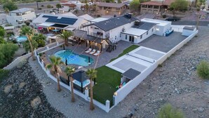 A residential property with a swimming pool, outdoor seating area, and a view of the ocean. - Iconic Views w/Pickleball & Gameroom | Pool & Spa (Lake Havasu City)