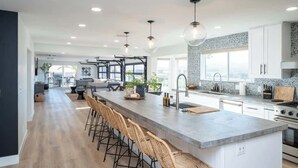 A modern kitchen with a central island, bar stools, and pendant lighting. - Iconic Views w/Pickleball & Gameroom | Pool & Spa (Lake Havasu City)