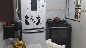 Une cuisine compacte équipée d’un réfrigérateur, d’un four à micro-ondes, d’une cuisinière et d’un coin repas avec une table et des chaises.