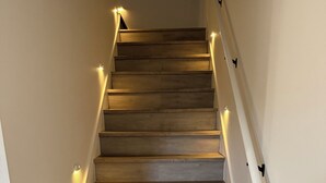 Una escalera de madera con paredes blancas y barandilla.