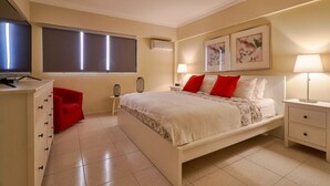 A bedroom with a bed, bedside tables, a desk, a chair, and a television. -  Penthouse in Evaristo Morales Sleeps 14 (Santo Domingo)