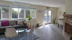 A living room with a sofa, a glass coffee table, and a fireplace.