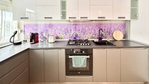Een moderne keuken met een inbouwoven, koffiezetapparaat en een spoelbak.
