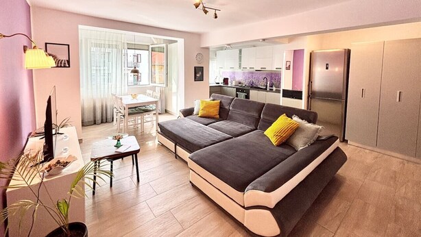 Een modern appartement met een groot bed, een eethoek en een keuken.