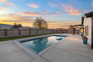 Une piscine offrant une vue dégagée sur le ciel, avec un arbre en arrière-plan.