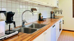 A kitchen with two sinks, a coffee maker, and a microwave.