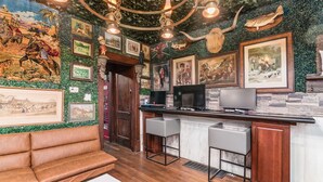 A bar area with a wooden counter, bar stools, and a mural with various artworks. - ★★ The Red Lion ★★. OSU British Pubcade Castle (Columbus)