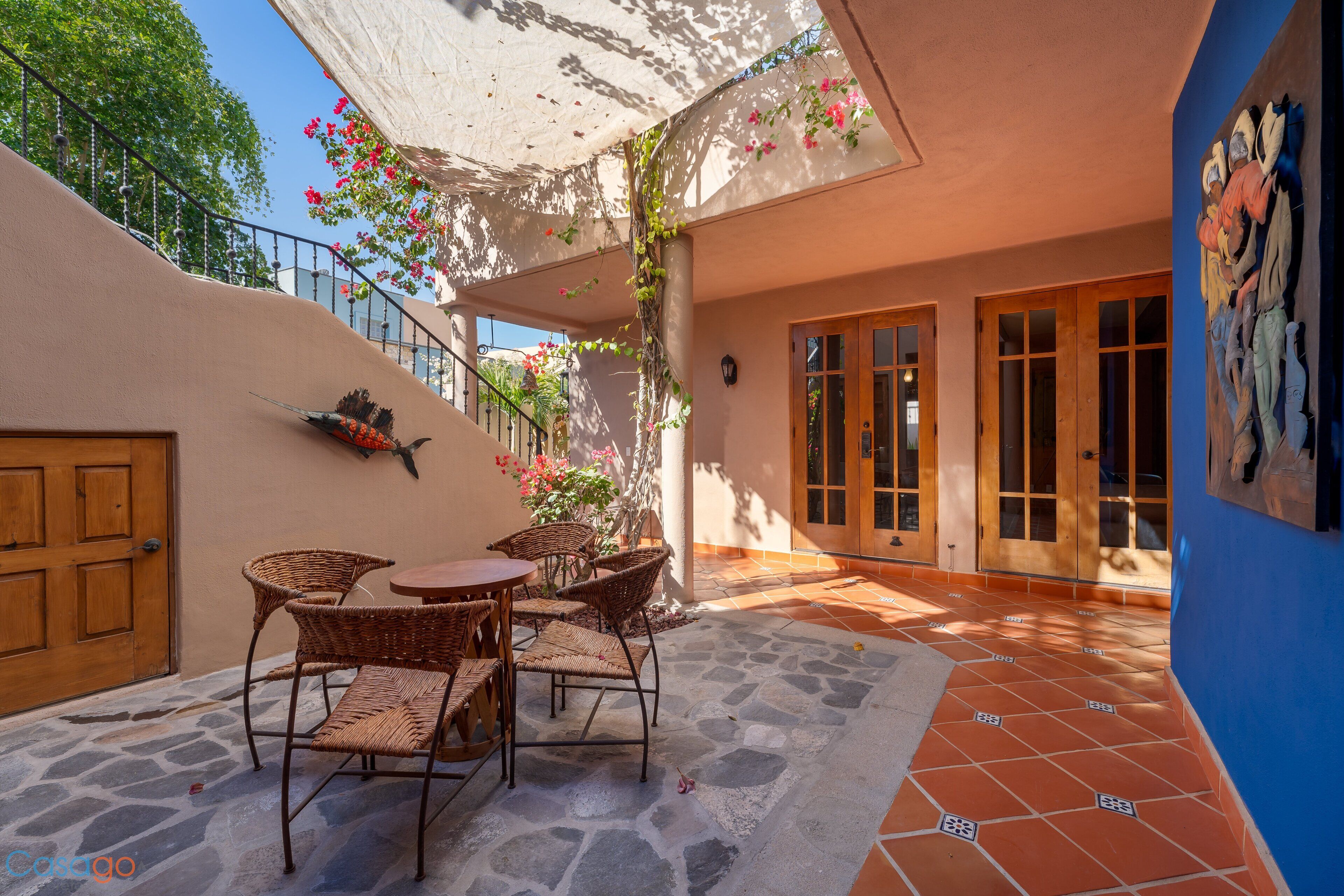 A patio area with stone flooring, wicker furniture, and a wooden door.