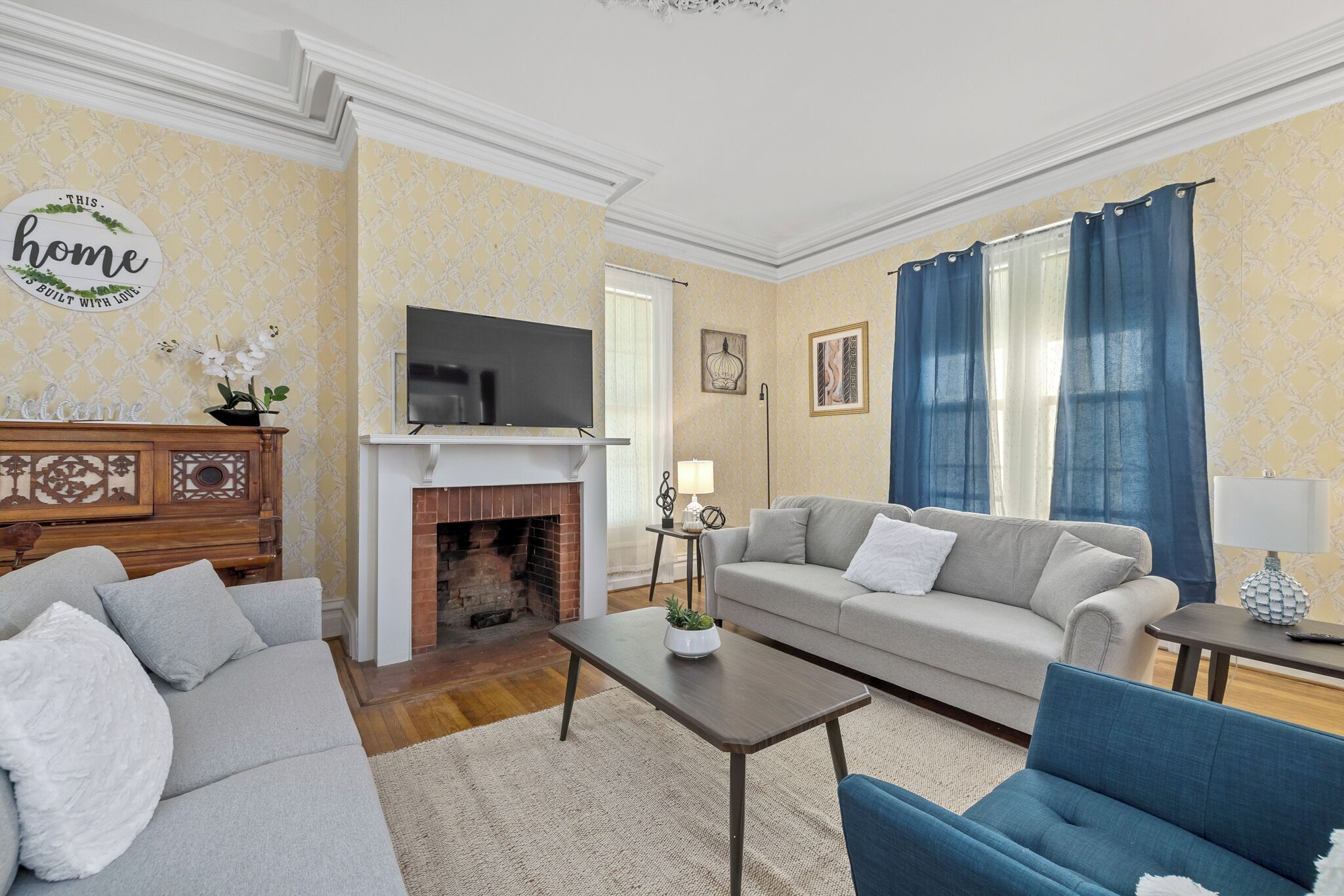 Een woonkamer met een open haard, bank en televisie.