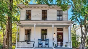 A two-story house with a front porch, a brick foundation, and a mailbox.