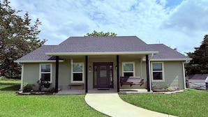 A single-story house with a front porch, a driveway, and a lawn. - Cielo’s Retreat, A Charming 3-bedroom farmhouse in McKinneyprincenton (McKinney)