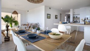 A modern kitchen with white cabinets, a wooden countertop, and a hanging light fixture. - Le Chantilly by Interhome (Cagnes-sur-Mer)