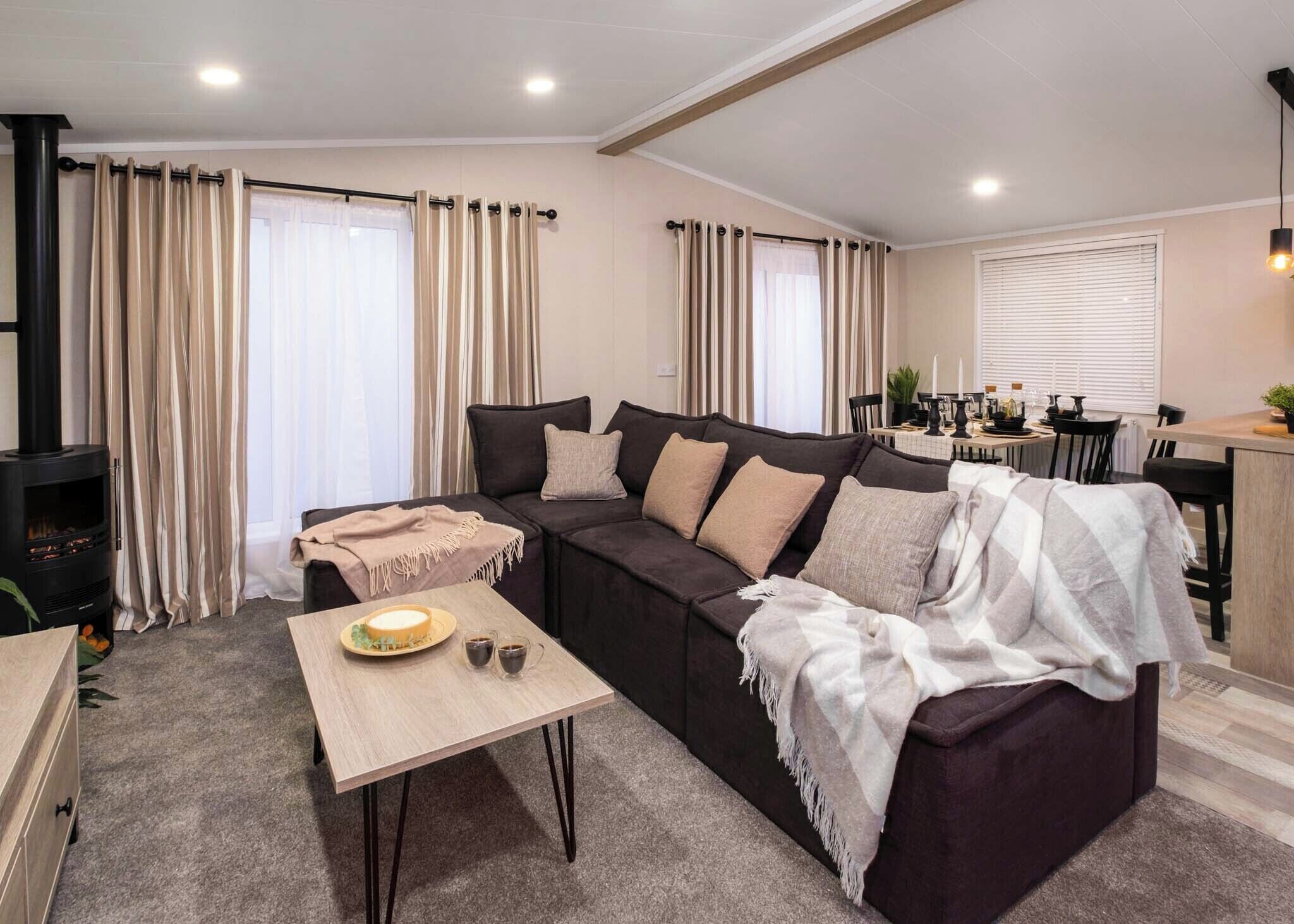A living room with a sofa, a coffee table, a fireplace, and a dining area.