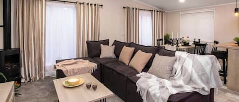 Ein Wohnzimmer mit einer Couch, einem Couchtisch, einem Kamin und einem Essbereich.
