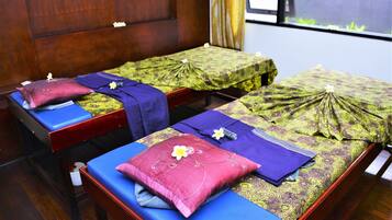 Relax in this serene space with two massage therapy beds, each featuring a massage table, pillow, and canopy.
