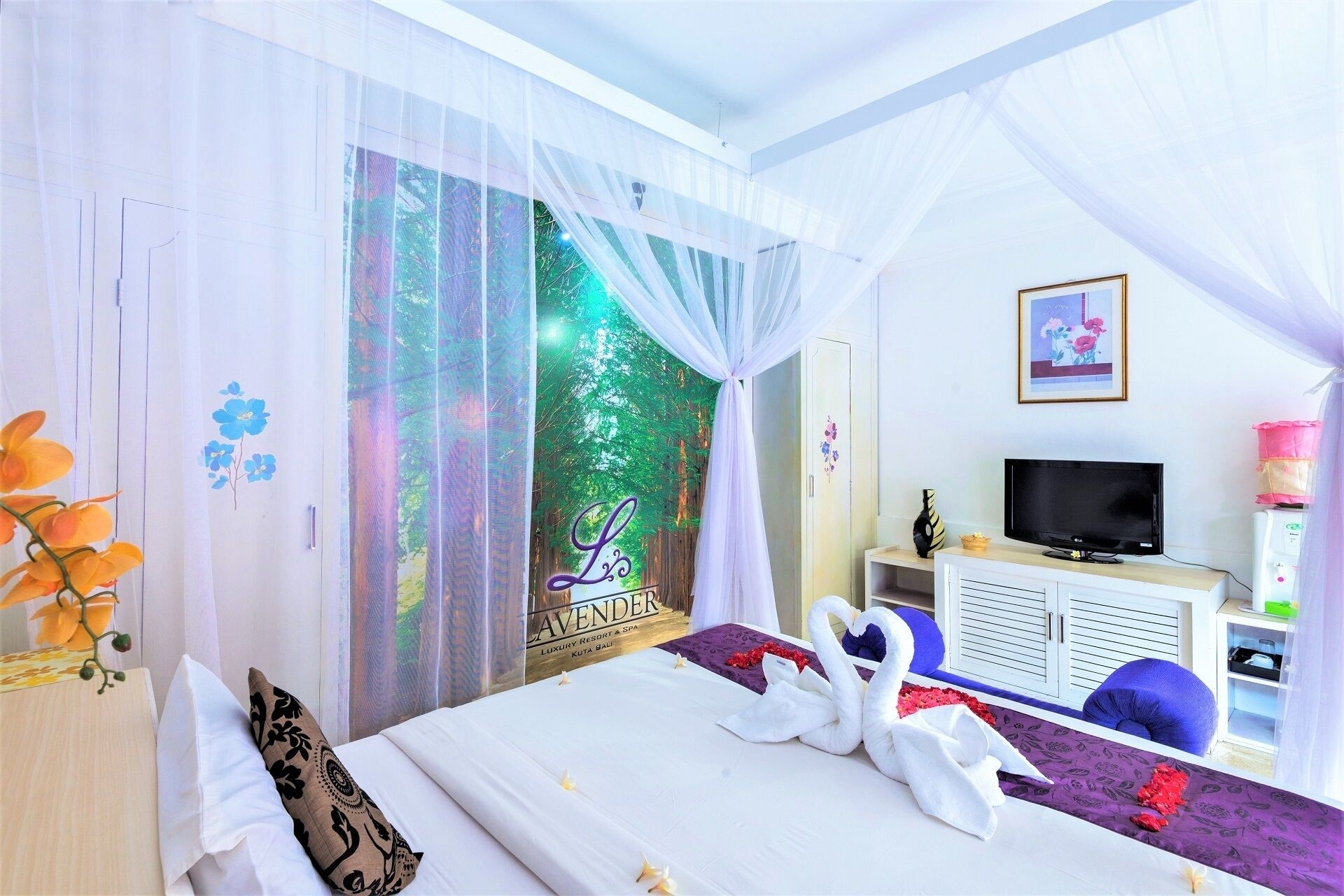 A hotel room with a bed, a TV, a cabinet, and a window with a forest view.
