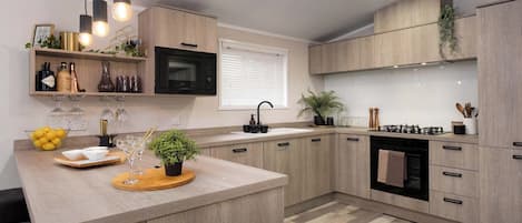 Una cocina moderna con armarios de madera, una isla central, un microondas y una estufa a gas.