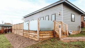 Il s’agit d’un bâtiment moderne de plain-pied, à l’extérieur gris, avec une clôture en bois et un petit escalier menant à une porte portant le numéro 2.