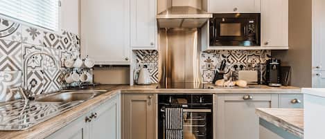 A modern kitchen with a stainless steel dishwasher, a built-in oven, and a microwave.