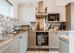 A modern kitchen with a stainless steel dishwasher, a built-in oven, and a microwave.