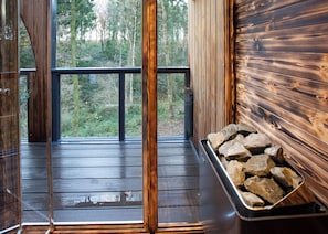 A wooden deck with a glass door leading to a forest view. - 1 bedroom accommodation in Ellesmere (Ellesmere)