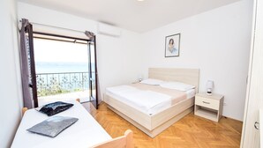 A bedroom with a bed, bedside table, and a view of the sea. - Apartment Lada by Interhome (Omiš)