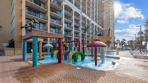 A hotel with a water park area featuring slides and a pool.