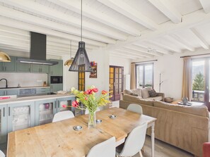 A spacious kitchen with modern appliances, a dining area with a wooden table, and a cozy living room with a sofa. - Estate for 8 people with swimming pool (Auriac-du-Périgord)