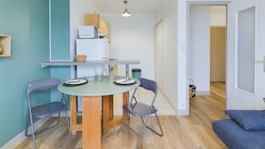 A compact living space with a dining area, kitchenette, and a sofa. - 100 m from the beach, 2 adults and 2 children (Fouesnant)