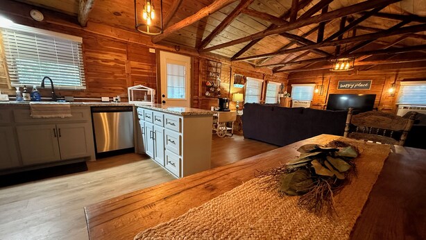 Interior acogedor de una cabaña con cocina, comedor y sala de estar.