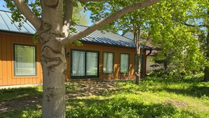 A modern house with large windows and a covered patio area. - Cozy Lake view 3-bedroom house WiFi, AC in Oshkosh-Great spaces inside & out EAA (Oshkosh)