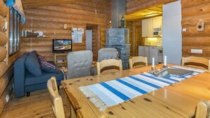 L’intérieur d’un chalet confortable, avec une table à manger, des chaises, un canapé et une cheminée.