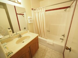 Bañera con ducha, secador de pelo, pantuflas, toallas
