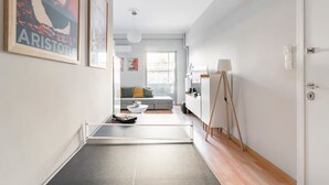 A modern apartment with a minimalist design, featuring a living area with a sofa and a dining table, a balcony with a view, and a painting on the wall. - Athenian Entertainment & Relaxation Hub (Athens)