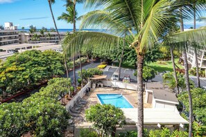 Un hotel con piscina, palme e vista sull'oceano.