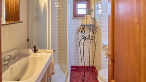 A bathroom with a white sink, a glass-enclosed shower, a toilet, and a wooden door. - Borgo  Fastelli - FASTELLI NOCE (Sarteano)