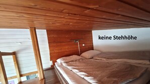 Ein Schlafzimmer mit Holzbalkendecke und einem Bett.