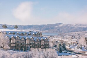 A multi-story hotel with a symmetrical facade, balconies, and a view of a lake and mountains. - Classic 3BD 3BTH at Moose Hollow, view of Mtns (Eden)