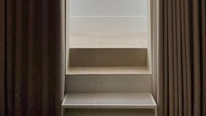 Una habitación con ventana, un banco y cortinas.
