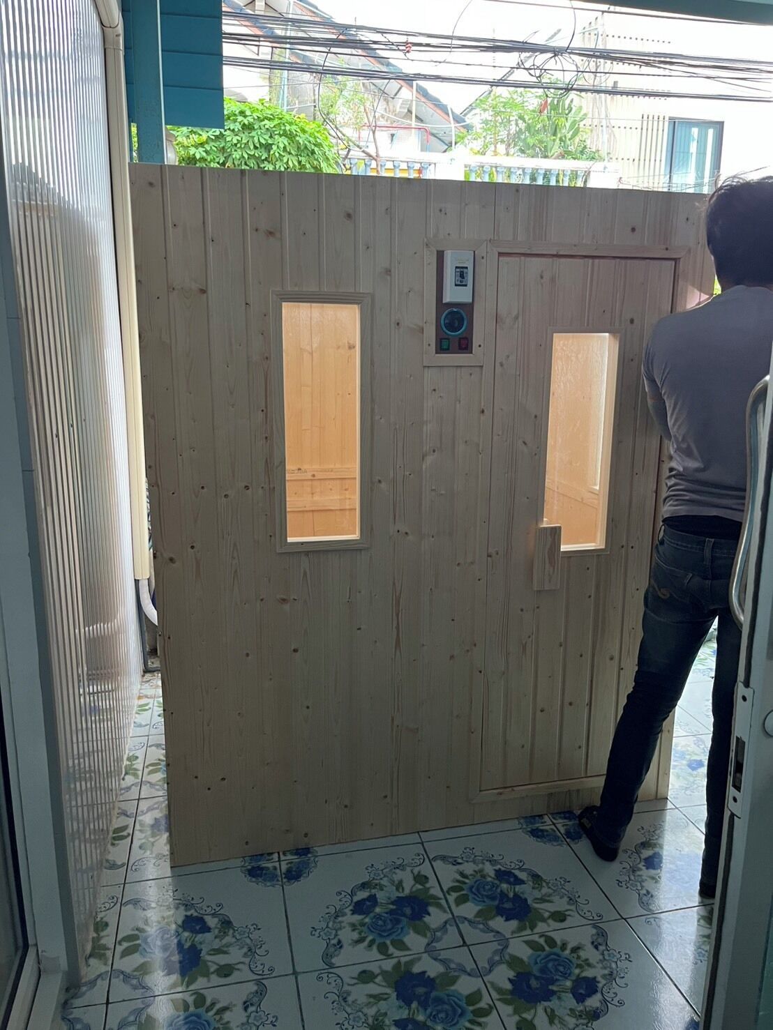 A wooden door with two rectangular windows and a control panel.